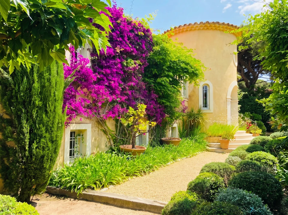 Professionnel en tenue de travail beige utilisant une tondeuse électrique sur pelouse verte bien entretenue dans jardin paysager avec arbustes taillés en arrière-plan